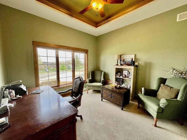 office with ceiling fan, carpet floors, a tray ceiling, and visible vents