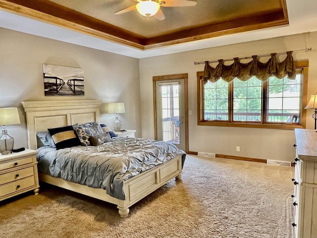bedroom with a raised ceiling, visible vents, access to outside, and multiple windows