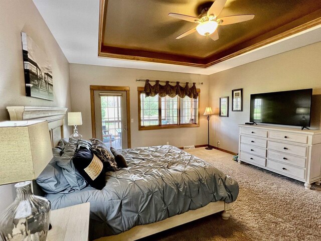 carpeted bedroom featuring visible vents, a fireplace, a tray ceiling, and access to outside