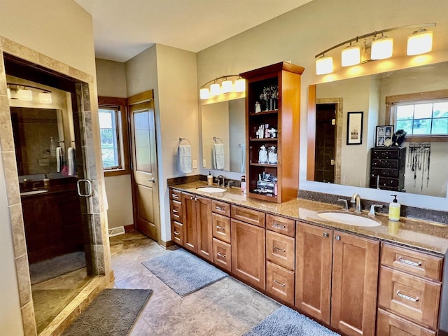 bathroom with a shower stall, plenty of natural light, and a sink
