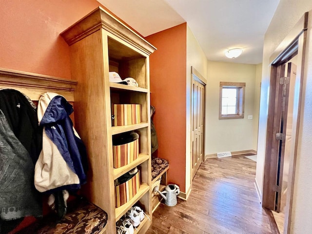 mudroom with baseboards, wood finished floors, and visible vents