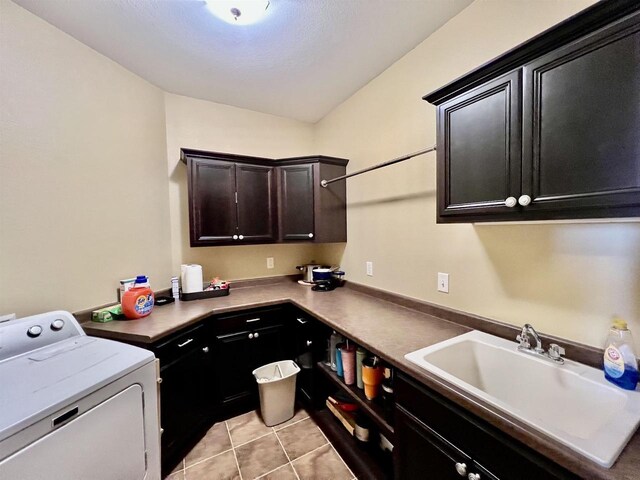 laundry area with a sink, cabinet space, light tile patterned floors, and washer / dryer