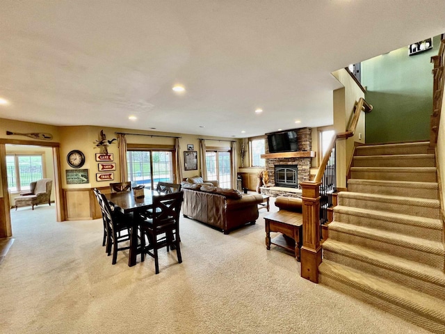 living area featuring a fireplace, light carpet, a healthy amount of sunlight, and recessed lighting