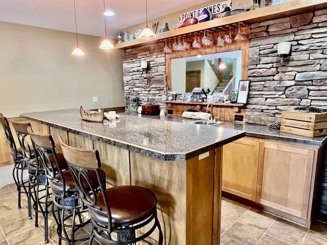 bar featuring pendant lighting, a sink, stairs, and light tile patterned flooring