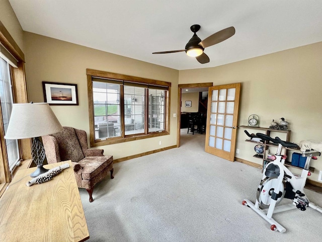 living area featuring baseboards, carpet floors, and ceiling fan