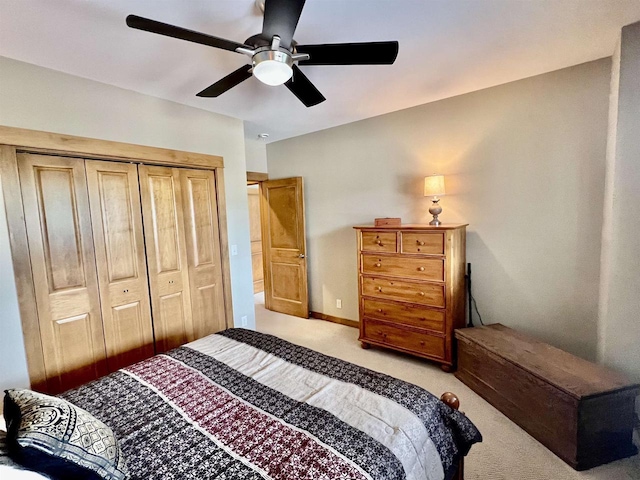 bedroom featuring a ceiling fan, a closet, and light colored carpet