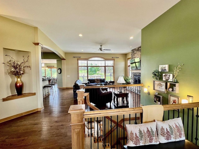 living room with wood finished floors, ceiling fan, arched walkways, baseboards, and recessed lighting