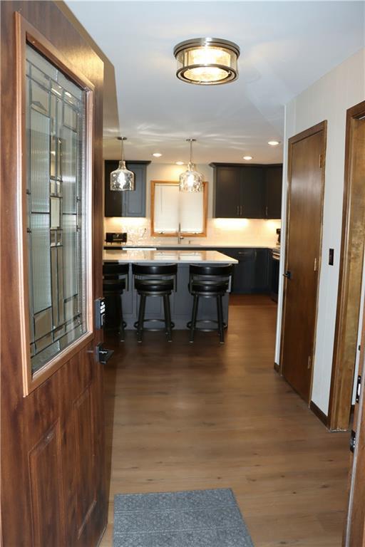 28942 Spring Green Way, Danbury, WI 54830 - kitchen featuring pendant lighting, light countertops, dark wood-style flooring, and a breakfast bar