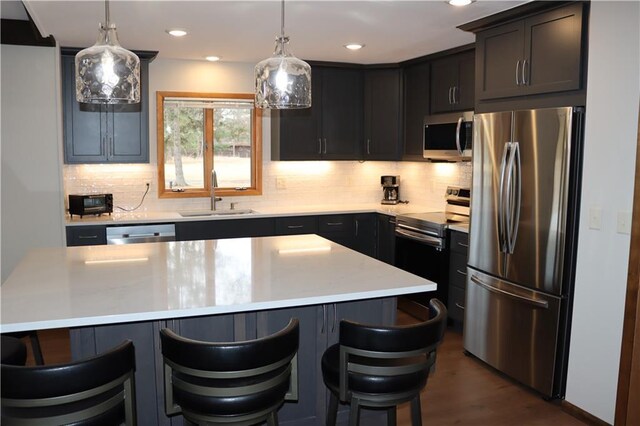 28942 Spring Green Way, Danbury, WI 54830 - kitchen featuring light countertops, a sink, a breakfast bar area, appliances with stainless steel finishes, and decorative backsplash