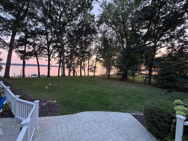 549 Illinois Ave, Green Lake, WI 54941 - yard at dusk with a water view and a patio area