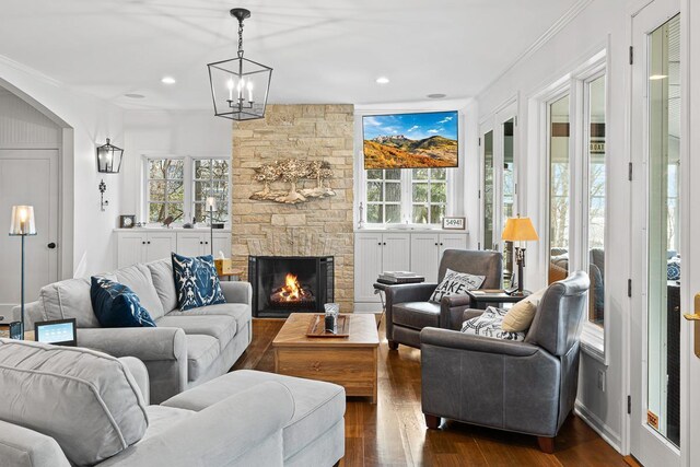 549 Illinois Ave, Green Lake, WI 54941 - living room with dark wood-style flooring, a stone fireplace, and a healthy amount of sunlight