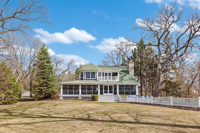 549 Illinois Ave, Green Lake, WI 54941 - back of house with a sunroom, a chimney, a yard, and a balcony