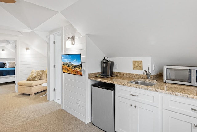 549 Illinois Ave, Green Lake, WI 54941 - kitchen with white cabinets, light carpet, stainless steel microwave, a sink, and fridge