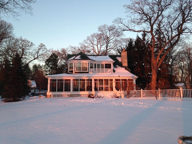 549 Illinois Ave, Green Lake, WI 54941 - rear view of property featuring fence, a sunroom, and a chimney