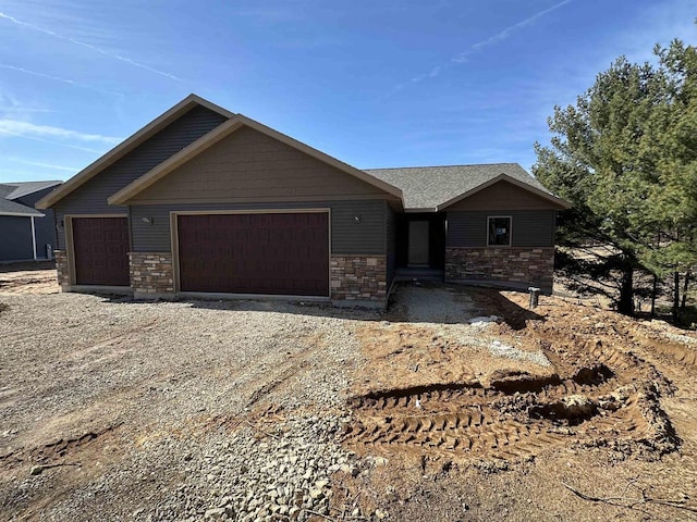 N1647 21st Ave, Wautoma, WI 54982 - view of front of house with a garage, driveway, stone siding, and roof with shingles