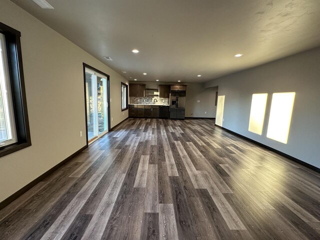 N1647 21st Ave, Wautoma, WI 54982 - unfurnished living room featuring recessed lighting, plenty of natural light, baseboards, and dark wood-style flooring
