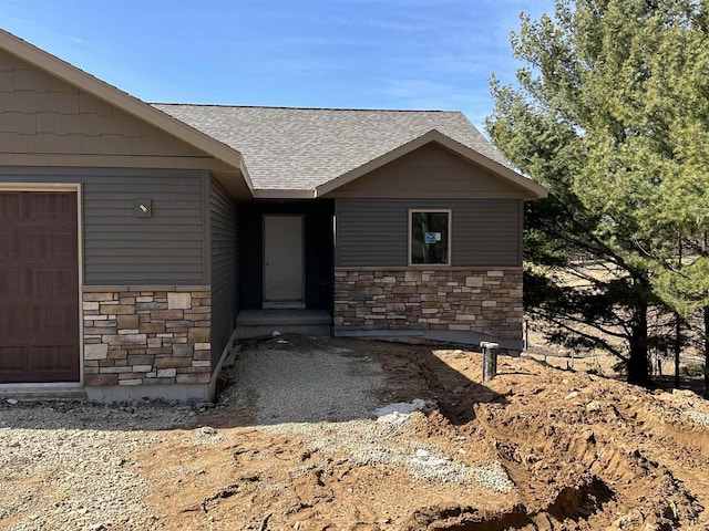 N1647 21st Ave, Wautoma, WI 54982 - doorway to property with an attached garage, stone siding, and a shingled roof