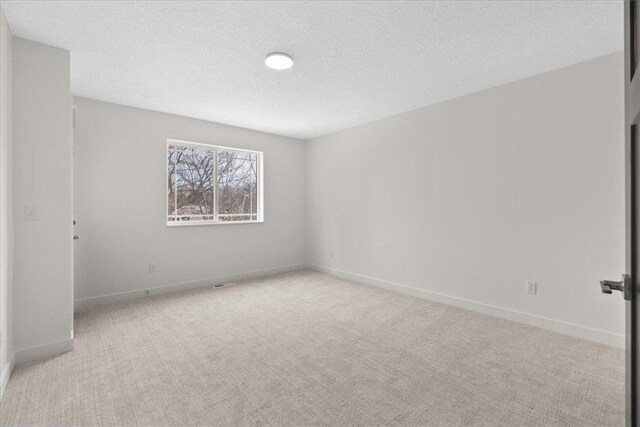 425 W 8th St Unit 20, New Richmond, WI 54017 - spare room with baseboards, carpet floors, and a textured ceiling