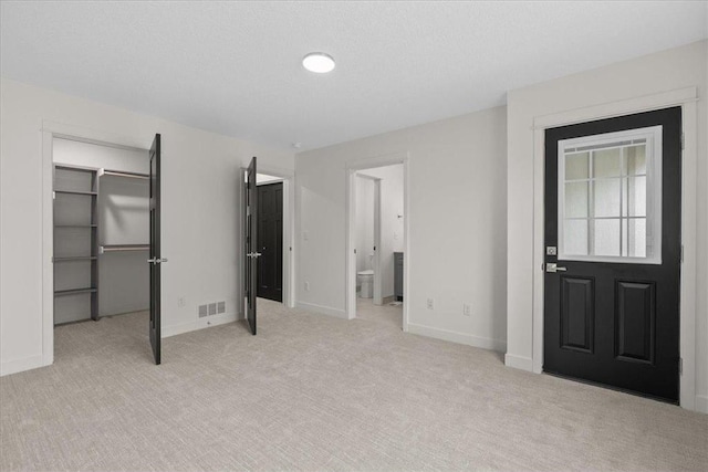 425 W 8th St Unit 20, New Richmond, WI 54017 - unfurnished bedroom with a closet, a spacious closet, baseboards, visible vents, and carpet