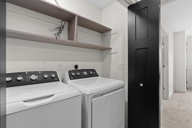 425 W 8th St Unit 20, New Richmond, WI 54017 - clothes washing area featuring baseboards, laundry area, separate washer and dryer, and light colored carpet