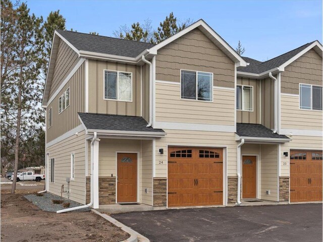 425 W 8th St Unit 20, New Richmond, WI 54017 - multi unit property with stone siding, board and batten siding, aphalt driveway, a garage, and a shingled roof