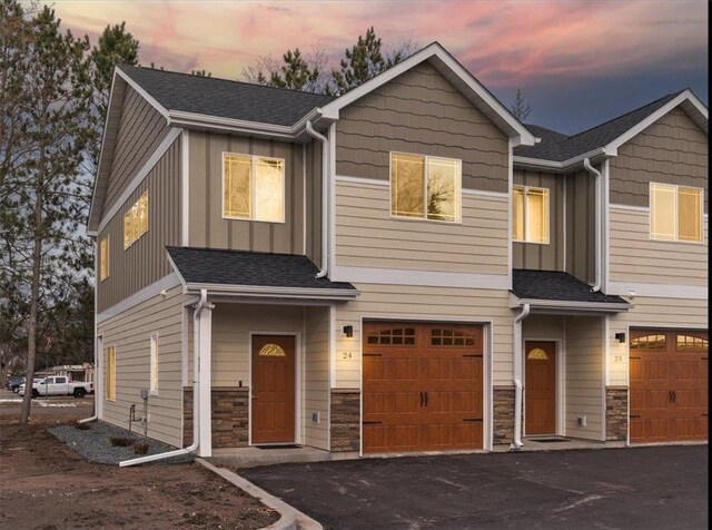 425 W 8th St Unit 20, New Richmond, WI 54017 - townhome / multi-family property with stone siding, board and batten siding, aphalt driveway, a shingled roof, and a garage