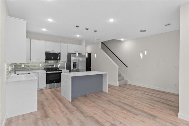 425 W 8th St Unit 20, New Richmond, WI 54017 - kitchen featuring light countertops, backsplash, a kitchen island, a sink, and stainless steel appliances
