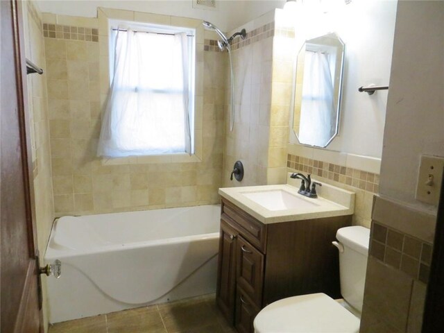 204 W Main St, Thorp, WI 54771 - bathroom featuring tile patterned floors, toilet, vanity, shower / bathing tub combination, and tile walls