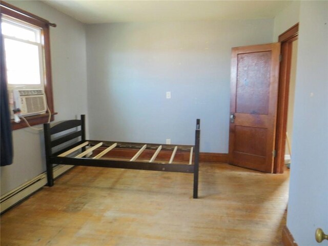 204 W Main St, Thorp, WI 54771 - bedroom with baseboards, cooling unit, and wood finished floors