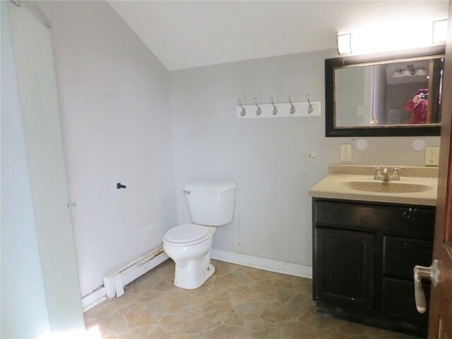 204 W Main St, Thorp, WI 54771 - bathroom with vaulted ceiling, toilet, vanity, baseboards, and a baseboard heating unit