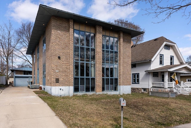 5928 W Michigan St, Wauwatosa, WI 53213 - view of property exterior featuring a yard, brick siding, and covered porch