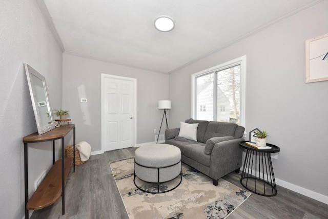 living area featuring ornamental molding, baseboards, and wood finished floors