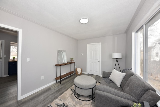 living room with dark wood-style flooring, crown molding, baseboards, and a textured ceiling