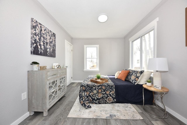 living area featuring baseboards, ornamental molding, and wood finished floors