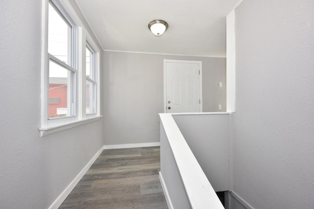 corridor with baseboards, an upstairs landing, and dark wood-style floors