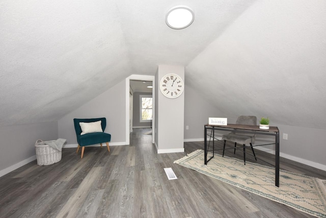 home office featuring a textured ceiling, baseboards, and wood finished floors