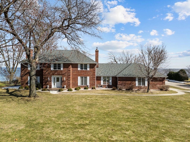 1370 Rahr Ave, Oshkosh, WI 54901 - view of front of home with a front lawn, a chimney, and brick siding