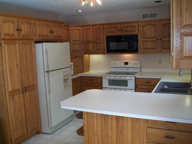 kitchen with visible vents, white appliances, light floors, a sink, and brown cabinetry