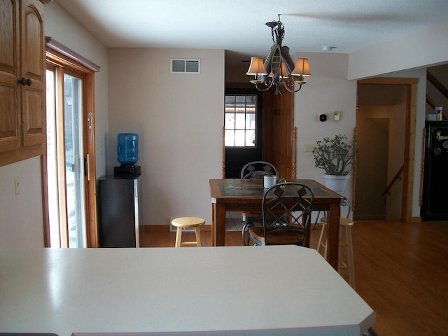 dining area with visible vents, wood finished floors, and a chandelier