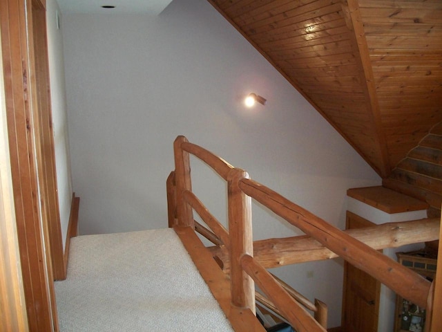 hall featuring lofted ceiling, an upstairs landing, and wooden ceiling