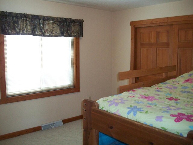 carpeted bedroom with baseboards and visible vents