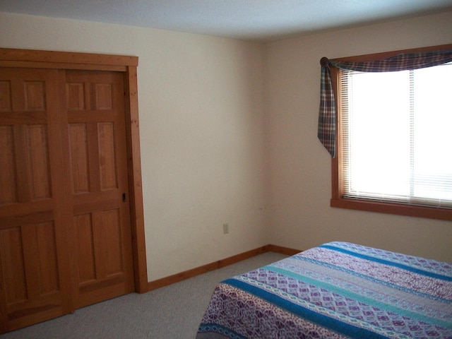 bedroom with baseboards and light colored carpet