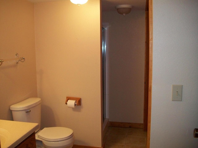bathroom with toilet, a stall shower, tile patterned flooring, and vanity