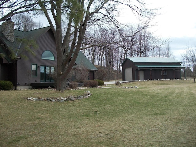 view of yard featuring a detached garage and an outdoor structure