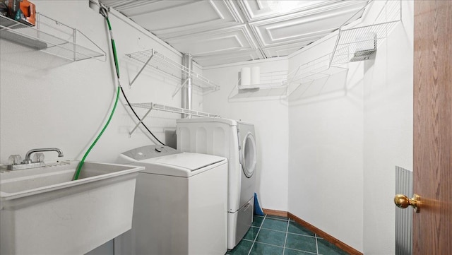 712 Water St, Genoa, WI 54632 - clothes washing area with baseboards, laundry area, dark tile patterned flooring, a sink, and separate washer and dryer