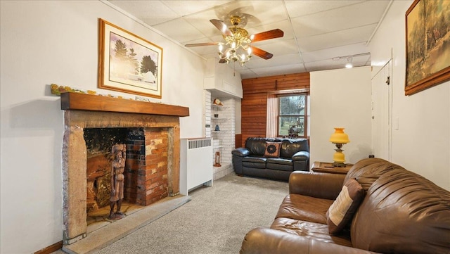 712 Water St, Genoa, WI 54632 - living area featuring a brick fireplace, rail lighting, ceiling fan, radiator heating unit, and carpet floors