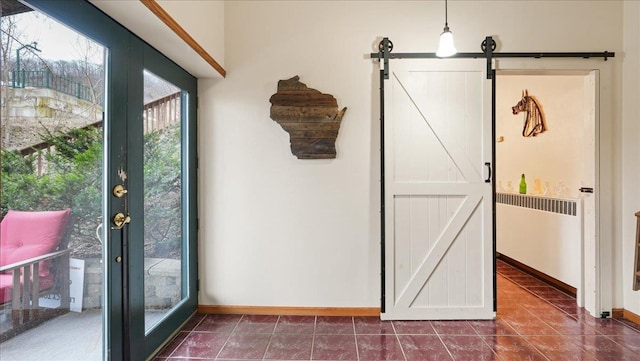 712 Water St, Genoa, WI 54632 - interior space with baseboards, a barn door, dark tile patterned flooring, and radiator heating unit