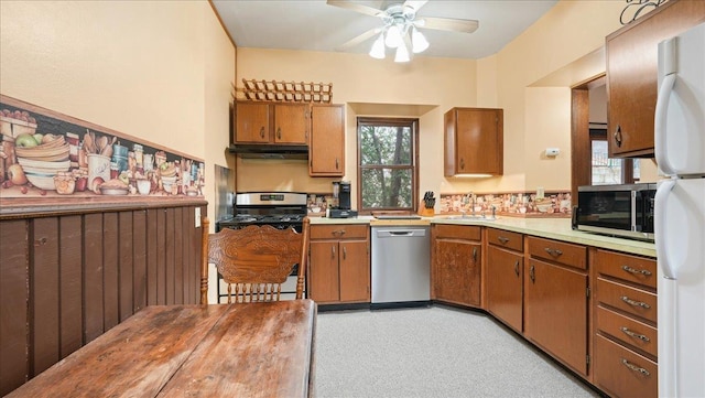 712 Water St, Genoa, WI 54632 - kitchen featuring brown cabinetry, a sink, appliances with stainless steel finishes, and under cabinet range hood