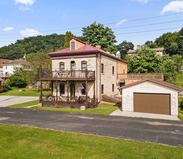 712 Water St, Genoa, WI 54632 - mediterranean / spanish-style home with stone siding, metal roof, a detached garage, a front lawn, and an outbuilding