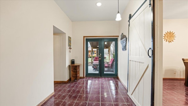 712 Water St, Genoa, WI 54632 - hall featuring baseboards, a barn door, dark tile patterned flooring, and french doors